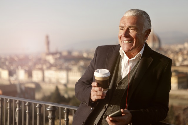 Starší muž v obleku s kávou