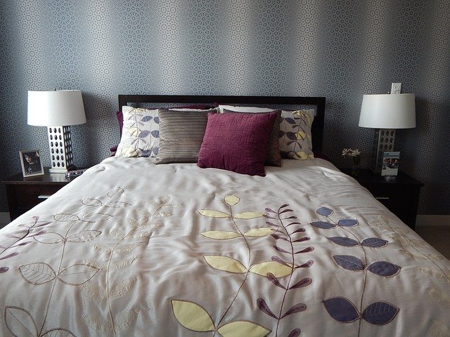 Manželská posteľ s dekou a farebnými vankúšmi